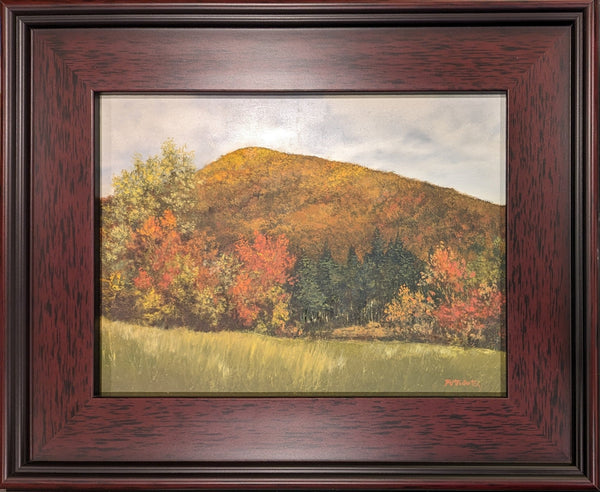 New England autumn hill painting with a ray of sun on top. This oil on panel painting captures the beauty of a simple New England hill in autumn. The hill is covered in a riot of red, orange, and yellow leaves, and a single ray of sunlight illuminates the top of the hill. The painting is framed in a dark walnut frame and is ready to hang.
