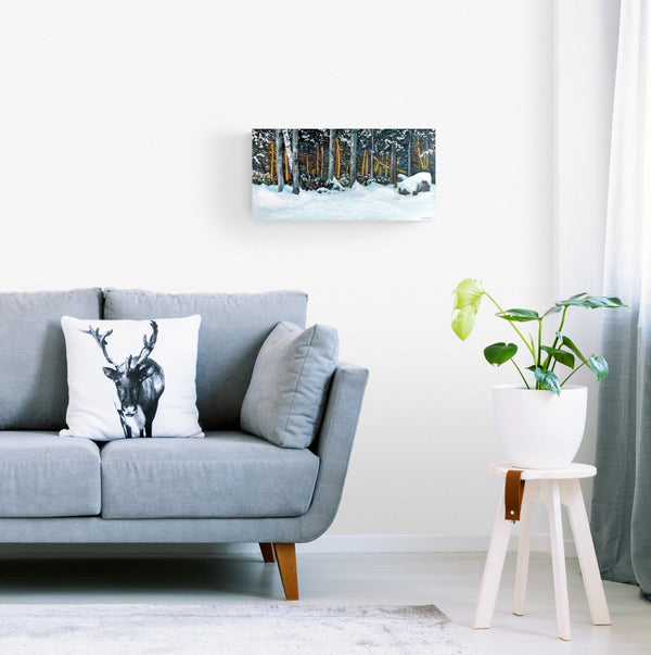 "Lights in the Trees" is an 11.75 by 23.5 inch oil on wood panel painting by Rebecca M. Fullerton. It depicts trees at the edge of the snowy forest, some of which are light with the orange light of dawn. Snow dusts the tree limbs, shrubs, rocks and ground below.