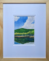 "Summer Idyll" is a 5 by 7 inch watercolor and ink painting by White Mountains artist Rebecca M. Fullerton, depicting a hill and puffy clouds reflected in a mountain pond.