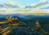 "Sunset Rays" is a framed 9 by 12 inch oil on panel painting depicting bright, orange and yellow shafts of sunset light stretching over rocks and small trees on a mountain summit. Rows of hills stretch into the soft light of the horizon.