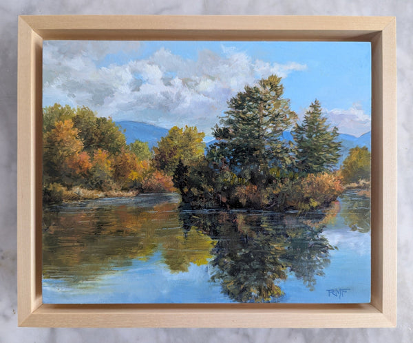 Framed painting of a landscape with trees and water