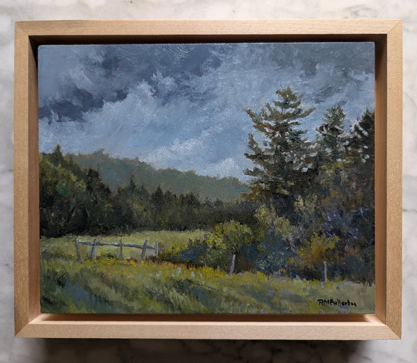 Framed painting of a landscape with trees and a field.