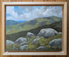 Painting of a mountain landscape with rocks and clouds in a wooden frame.