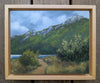 Framed painting of a mountain landscape with a path and trees.