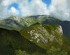 Mountain landscape with green slopes and a cloudy sky