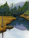 Golden grasses on the edges of a river with mountains reflected in the water