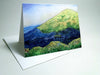A small blank greeting card with a high-quality print of an original painting depicting a mountainous landscape, including a hut nestled between mountains.